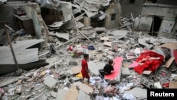 Anak-anak Palestina memeriksa lokasi serangan Israel di sebuah rumah, di tengah konflik Israel dan Hamas, di Rafah di selatan Jalur Gaza, 27 April 2024. (Foto: Reuters)