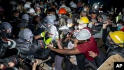 Sejumlah anggota polisi tampak berusaha membubarkan para demonstran pro-Palestina di kampus UCLA di Los Angeles, pada 2 Mei 2024. (Foto: AP/Ethan Swope)