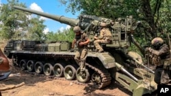 Russian soldiers operate 2S7M Malka self-propelled cannon in an undisclosed location, in this photo taken from video, July 23, 2024. (Russian Defense Ministry Press Service via AP)