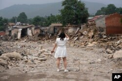 A woman looks for her house after floodwaters devastated Nanxinfang village on the outskirts of Beijing, Aug. 4, 2023. Severe floods in China's northern province of Hebei was caused by remnants of Typhoon Doksuri.