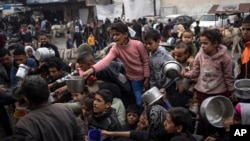 2023年12月21日，巴勒斯坦人在加沙地带拉法排队领取免费餐食。（美联社照片）