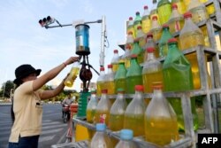 រូបឯកសារ៖ ស្ត្រីម្នាក់កំពុងចាក់សាំងដាក់ដបសម្រាប់អាជីវកម្មរបស់ខ្លួន នៅរាជធានីភ្នំពេញ កាលពីថ្ងៃទី ១៥ ខែធ្នូ ឆ្នាំ ២០១៩។