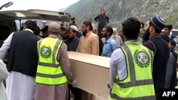 FILE - Volunteers transport the coffins of Chinese nationals from a hospital following a suicide attack in Besham city in the Shangla district of Pakistan's Khyber Pakhtunkhwa province on March 26, 2024.