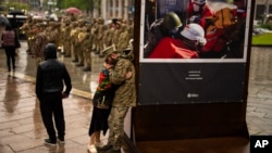 Vojnik tuguje u zagrljaju žene tokom ceremonije sahrane bolničara ukrajinske vojske Nazarija Lavrovskog (31), poginulog u ratu, na Trgu nezavisnosti u Kijevu, 24. aprila 2024. (Foto: AP)