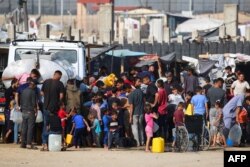 Pengungsi Palestina mengantre untuk membeli air dari truk air di sebelah kamp sementara mereka di Rafah di tengah konflik yang sedang berlangsung antara Israel dan kelompok militan Hamas, 17 Mei 2024. (Foto: AFP)