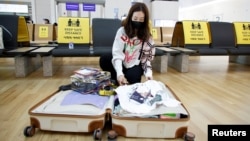 ILUSTRASI - Kim Ji-eun, seorang wisatawan, memeriksa isi kopernya di bandara internasional Incheon, Korea Selatan, 25 November 2021. (REUTERS/ Heo Ran)
