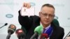 Tomasz Szmydt, a Polish judge who requested political asylum in Belarus, shows his ID document during a press conference in Minsk, Belarus, May 6, 2024. (BelTA/Maxim Guchek/Handout via Reuters)