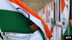 Seorang pelaut India yang memegang Tricolor di depan Gerbang India di Mumbai, 2 Desember 2011. Angkatan Laut India mengatakan pihaknya tengah memperkuat pasukan di pulau-pulau yang dianggap "penting secara strategis" dekat Maladewa. (Foto: AFP)
​