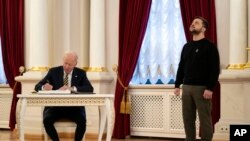 Američki predsednik Džo Bajden upisuje se u knjigu gostiju tokom susreta sa ukrajinskim predsednikom Volodimirom Zelenskim u Kijevu (Foto: AP/Evan Vucci, Pool)