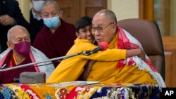 Seorang anak laki-laki memeluk pemimpin spiritual Tibet Dalai Lama dalam sebuah acara di mana pemimpin Tibet itu berbicara kepada sekelompok siswa di kuil Tsuglakhang di Dharamshala, India, Selasa, 28 Februari 2023. (Foto: AP)