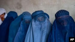 FILE - Afghan women wait to receive food rations distributed by a humanitarian aid group, in Kabul, Afghanistan, May 23, 2023. An NGO has urged the U.N. to demand the Taliban ensure full and equal participation of Afghan women in all discussions about Afghanistan's future. 