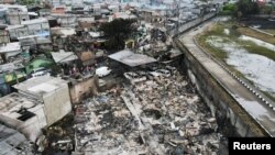 Reruntuhan dan kendaraan yang rusak di daerah perumahan yang terkena dampak kebakaran di Depo Pertamina Plumpang, Jakarta, 4 Maret 2023. (REUTERS/Willy Kurniawan)