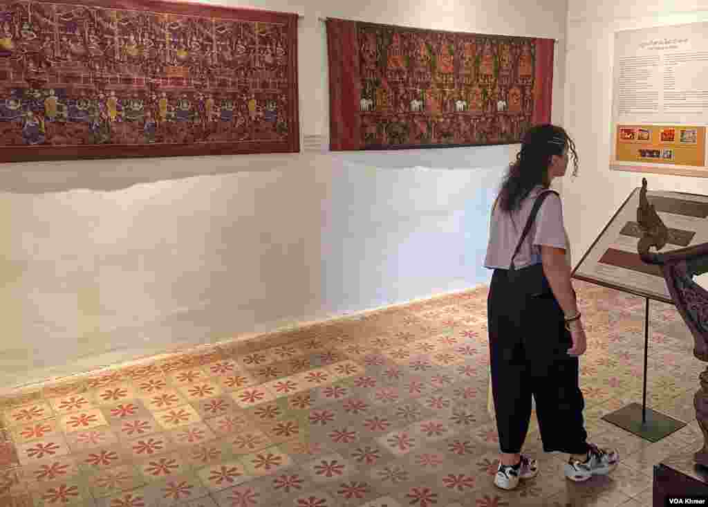 នារីម្នាក់កំពុងអានព័ត៌អំពីហូលពិតានខ្មែរនៅសារមន្ទីជាតិ ក្នុងរាជធានីភ្នំពេញ កាលពីថ្ងៃទី២៧ ខែមីនា ឆ្នាំ២០២៤។ (ស៊ឹម ចាន់សំណាង/វីអូអេខ្មែរ)