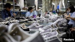 រូបឯកសារ៖ កម្មករោងចក្រនាំចេញស្បែកជើងកំពុងធ្វើការ​ នៅក្រុងហាណូយ ប្រទេសវៀតណាម កាលពីថ្ងៃទី២៩ ខែធ្នូ ឆ្នាំ២០២០។ 