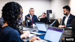 NATO Secretary-General Jens Stoltenberg, center, previews the alliance's upcoming summit for a small group of reporters including VOA’s Misha Komadovsky, right, in Washington, July 7, 2024.