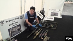 At a facility in Tzrifin, Israel, Dec. 28, 2023, VOA Korean Service reporter Jiha Ham points to weapons the Israel Defense Forces say were captured from Hamas, including North Korean-made rocket propelled grenades. (Sanghoon Lee/VOA Korean)