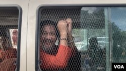 រូបឯកសារ៖ លោក ថាច់ សេដ្ឋា អនុប្រធានគណបក្សភ្លើងទៀន បង្ហាញខ្នោះដៃពីក្នុងឡាន នៅពេលលោកត្រូវបានដឹកចេញពីតុលាការកំពូលទៅពន្ធនាគារព្រៃស កាលពីថ្ងៃទី១៩ ខែមិថុនា ឆ្នាំ២០២៣។ (លាស់ លីបលីប/វីអូអេ)