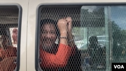 រូប​ឯកសារ៖ លោក ថាច់ សេដ្ឋា អនុប្រធានគណបក្សភ្លើងទៀន បង្ហាញខ្នោះដៃពីក្នុងឡាន នៅពេលលោកត្រូវបានដឹកចេញពីតុលាការកំពូលទៅពន្ធនាគារព្រៃស កាលពីថ្ងៃទី១៩ ខែមិថុនា ឆ្នាំ២០២៣។ (លាស់ លីបលីប/វីអូអេ)