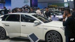 Sejumlah pengunjung memperhatikan mobil-mobil yang dipamerkan dalam China Auto Show di Beijing, China, 26 April 2024. (Foto: Tatan Syuflana/AP Photo)