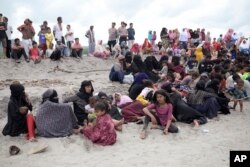 Pengungsi Rohingya beristirahat di pantai Lampanah Leungah setelah mendarat di Aceh Besar, Provinsi Aceh, Kamis, 16 Februari 2023. (AP/Riska Munawarah)