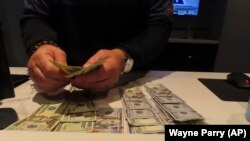 Frank Kaltađirone, uposlenik kladionice u "Ocean Casino Resortu" u Atlantik sitiju, broji novac koji su igrači uložili na njegovom radnom mjestu, 6. februara 2023. godine.