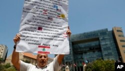 FILE - An anti-Hezbollah protester holds a banner during a sit-in in Beirut, Lebanon, July 24, 2020.
