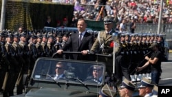 2023年8月15日，波兰总统杜达在抵达波兰华沙参加大规模阅兵式时向部队致意。（美联社照片）