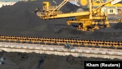Seorang pekerka mengendarai sepeda motor melintas di pelabuhan batu bara di Provinsi Quang Ninh, 200 kilometer dari Hanoi, 16 September 2011. (Foto: Kham/Reuters)