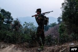 FILE - In this photo taken on March 9, 2023, a member of the Taang National Liberation Army, an ethnic rebel group, patrols near Namhsan township in Myanmar's northern Shan state.