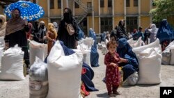 Perempuan Afghanistan menerima jatah bantuan makanan yang didistribusikan oleh kelompok bantuan kemanusiaan, di Kabul, Afghanistan (foto: dok).