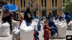 FILE - Perempuan Afghanistan menerima jatah makanan yang didistribusikan oleh kelompok bantuan kemanusiaan, di Kabul, Afghanistan, Minggu, 28 Mei 2023. (AP/Ebrahim Noroozi)
