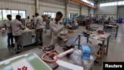 资料照：印度艾哈迈达巴德市郊的一座工厂内工人正在组装变压器。（2024年3月28日）