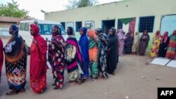 Internally displaced women wait in a queue to collect aid from a group at a camp in Gadaref on May 12, 2024, while clashes reignited between the Sudanese army and rival paramilitaries in the key Darfur town of El Fasher.