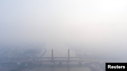 A view shows the Ampera bridge covered with smog due to wildfires in Palembang, South Sumatra province, Indonesia, Oct. 1, 2023, in this photo taken by Antara Foto. (Antara Foto/Nova Wahyudi/via Reuters) 
