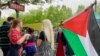 A protester holds a Palestinian flag and the traditional May Day bouquet at the Place de la Republique in Paris.