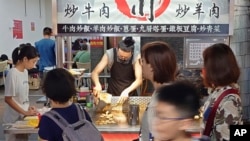 FILE - People go to the night market to shop in Taipei, Aug. 28, 2023.
