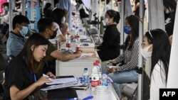 FILE - The photo taken on Aug. 26, 2022, shows young people attending a job fair in Beijing.