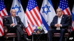 FILE - U.S. President Joe Biden, left, pauses during a meeting with Israeli Prime Minister Benjamin Netanyahu, in Tel Aviv, Israel, Oct. 18, 2023.
