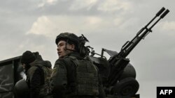 A Ukrainian serviceman stands in front of an anti-aircraft machine gun, in Siversk, Donbas region, March 7, 2023.