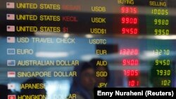 Sebuah papan elektronik berisi nilai tukar mata uang asing terpampang di tempat penukaran uang di Jakarta, 11 Juni 2013. (Foto: Enny Nuraheni/Reuters)