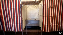 FILE - A booth is ready for a voter at City Hall in Cambridge, Mass., Feb. 24, 2020.