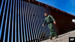 Border Patrol Deputy Chief for the Tucson Sector Justin De La Torre walks along the border fence of the US-Mexico border, Aug. 29, 2023, in Organ Pipe Cactus National Monument near Lukeville, Ariz.