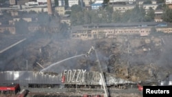 俄军袭击摧毁敖德萨一座购物中心后，救援人员在现场工作。(2023年8月14日)