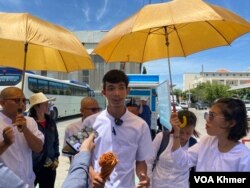 លោក លី ចាន់ដារ៉ាវុត និងសកម្មជនមាតាធម្មជាតិផ្សេងទៀត ផ្ដល់បទសម្ភាសន៍ដល់អ្នកសារព័ត៌មាន នៅច្រកចូលសាលាដំបូងរាជធានីភ្នំពេញ នៅថ្ងៃទី៥ ខែមិថុនា ឆ្នាំ២០២៤។ (ទឹម រក្សា/វីអូអេ)