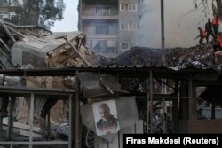 Foto mendiang komandan militer senior Iran, Jenderal Qassem Soleimani, terpampang di antara puing-puing di konsulat Iran di ibu kota Suriah, Damaskus, 1 April 2024. (Foto: REUTERS/Firas Makdesi)
