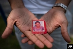 Mohamed, who fled political persecution in Mauritania, holds a picture of himself as a child, May 22, 2023, outside the Crossroads Hotel in Newburgh, N.Y.