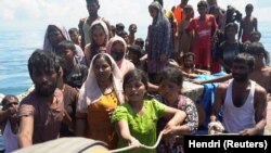 Pengungsi Rohingya memegang tali saat diselamatkan dari perahu yang terbalik di perairan Aceh Barat, 21 Maret 2024. (Foto: REUTERS/Hendri)