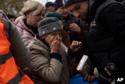 Žena reaguje nakon što je dobila pomoć u hrani od Vorld central kičena u Hersonu, Ukrajina, 17. novembra 2022. Slika je bila deo serije fotografija fotografa Asošijeted presa koje su bile u finalu izbora za dodelu Pulicerove nagrade za fotografiju 2023. AP je dobio priznanje za fotografiju hitne vesti.