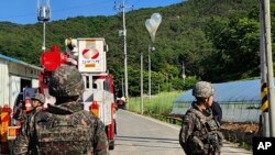 Dalam foto yang disediakan oleh Markas Besar Pemadam Kebakaran Jeonbuk ini, balon berisi sampah yang tampaknya dikirim oleh Korea Utara, digantung di kabel listrik saat tentara Korea Selatan berjaga di Muju, Korea Selatan, 29 Mei 2024.