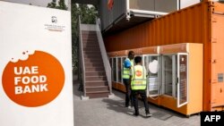 FILE - Para pekerja di Bank Makanan UEA membuka lemari es di lokasi di Dubai, 27 Maret 2023. (Karim SAHIB / AFP)